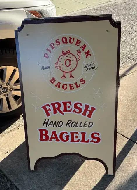 The Pipsqueak Bagels sandwich board on the sidewalk: fresh, hand rolled bagels