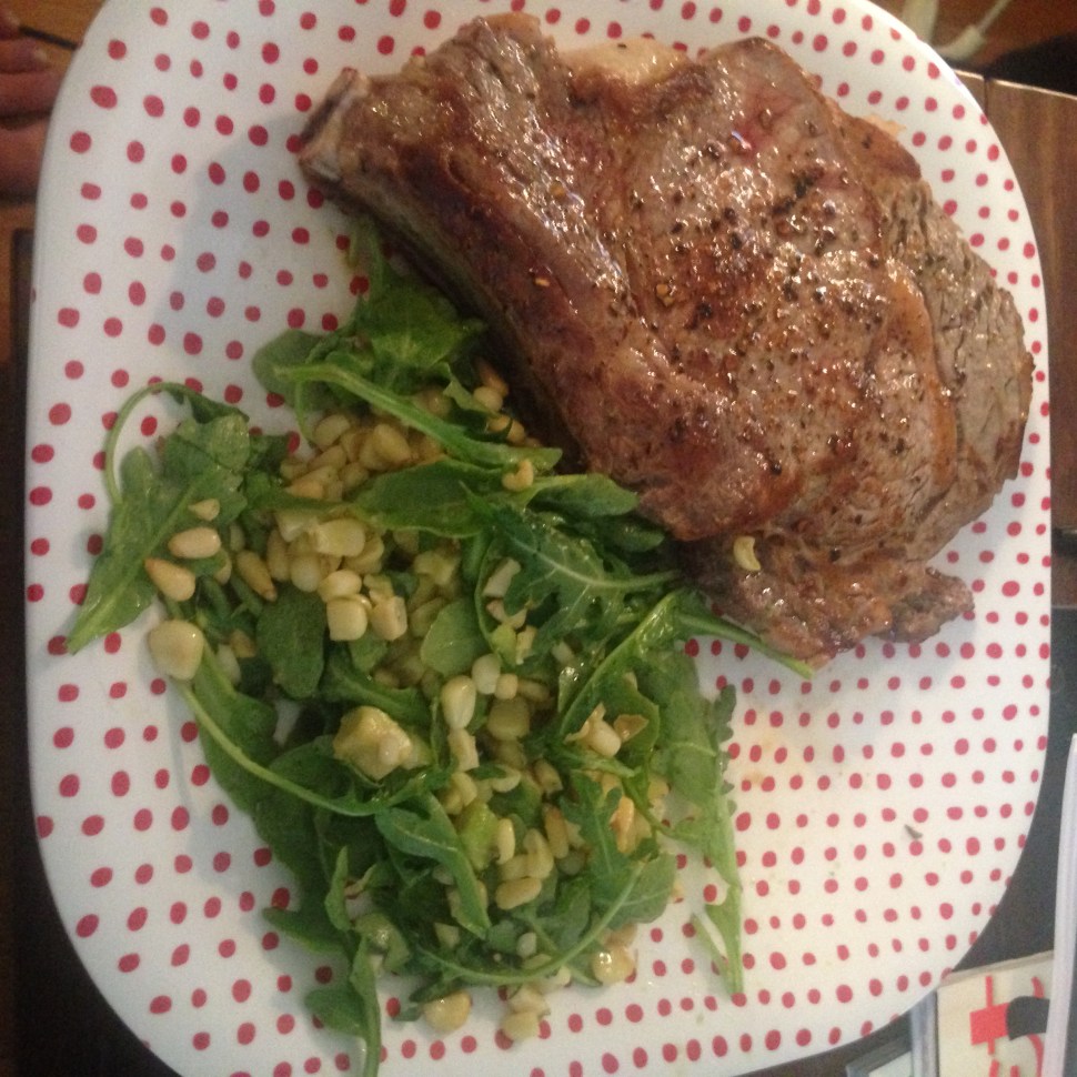 Ribeye steak with a corn, avocado, arugula salad on some lovely child safe plates